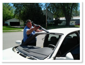 Mike applying sealant adhesive to a car windshield frame